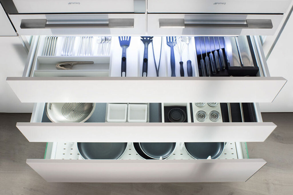 Un cajón repleto de utensilios de cocina, con una variedad de herramientas esenciales para la preparación de alimentos. Cada elemento está cuidadosamente organizado para facilitar el acceso y maximizar el espacio en la cocina.