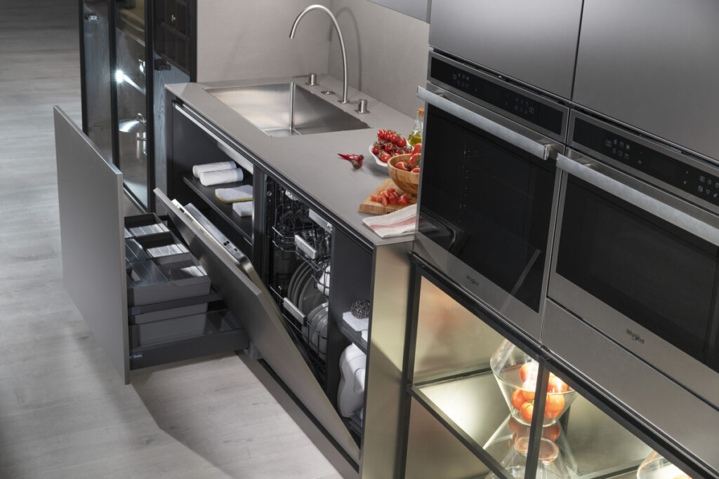 Módulo de fregadero con lavavajillas integrado y cajones organizadores ocultos. Superficie de acero inoxidable que aporta continuidad visual y practicidad. Todo se alinea en un diseño elegante y altamente funcional.