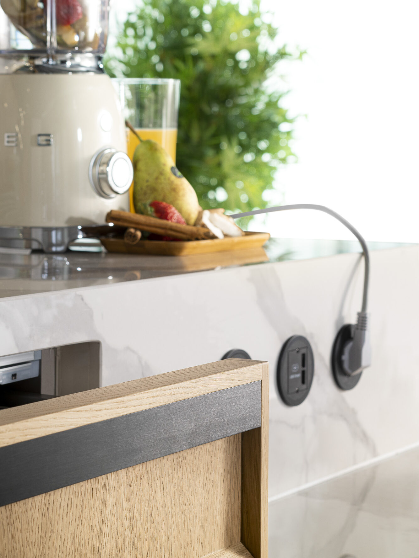 Una cocina moderna con un elegante mostrador donde se destacan una licuadora y una variedad de frutas frescas. La combinación de electrodomésticos de calidad y el diseño funcional crean un ambiente acogedor y práctico para cocinar.
