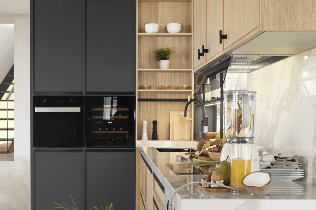 Cocina moderna con muebles de madera clara, líneas rectas y detalles en negro. Diseño funcional y elegante que combina calidez y estilo.