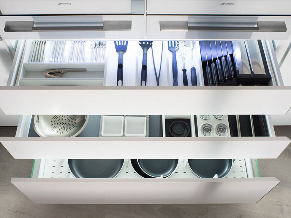 Un cajón repleto de utensilios de cocina, con una variedad de herramientas esenciales para la preparación de alimentos. Cada elemento está cuidadosamente organizado para facilitar el acceso y maximizar el espacio en la cocina.