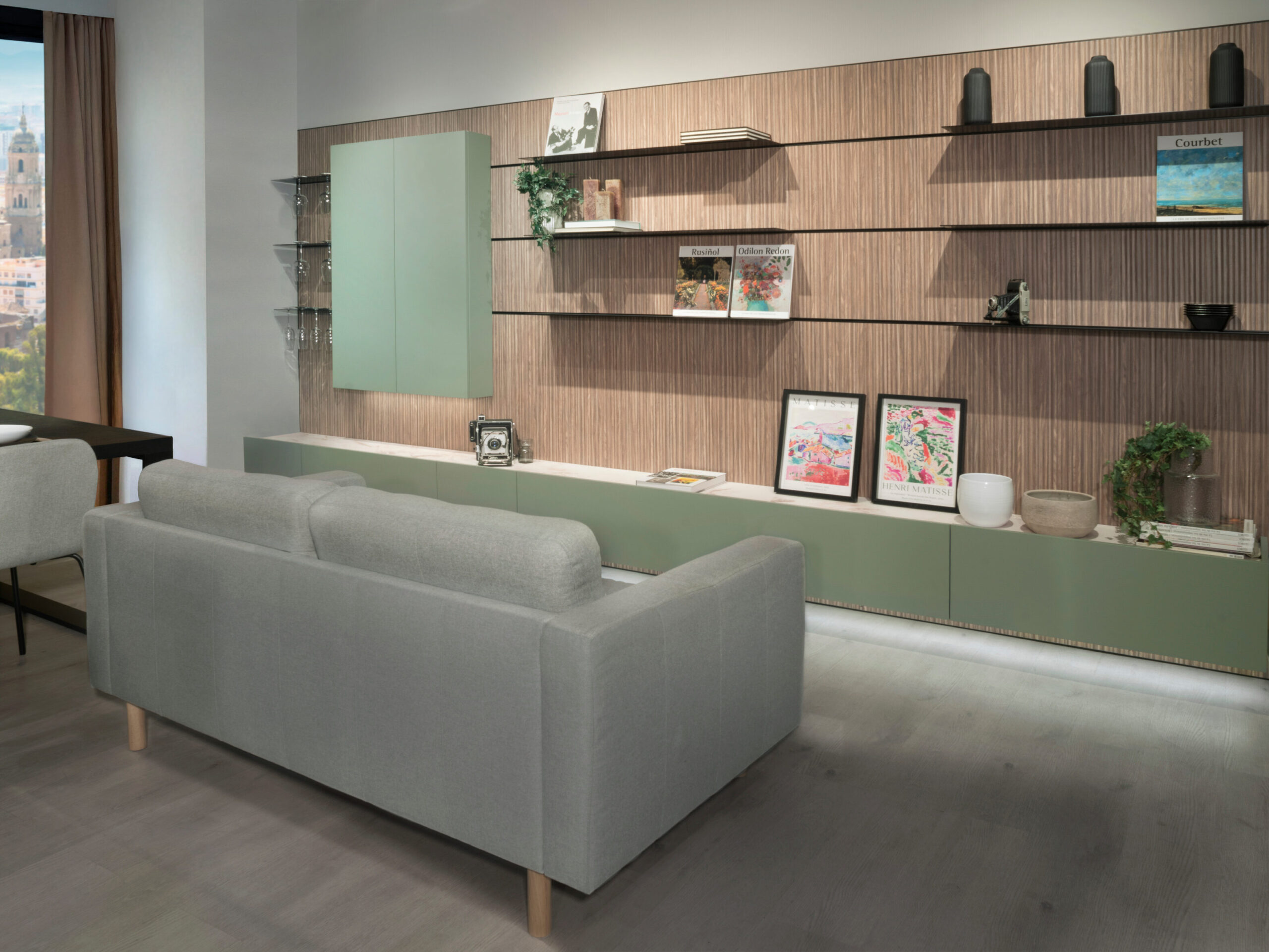 Un sofá cómodo en la sala, con un diseño moderno que complementa el estilo del espacio. La estantería al fondo añade funcionalidad y un toque decorativo a la habitación. Ideal para relajarse o recibir visitas.